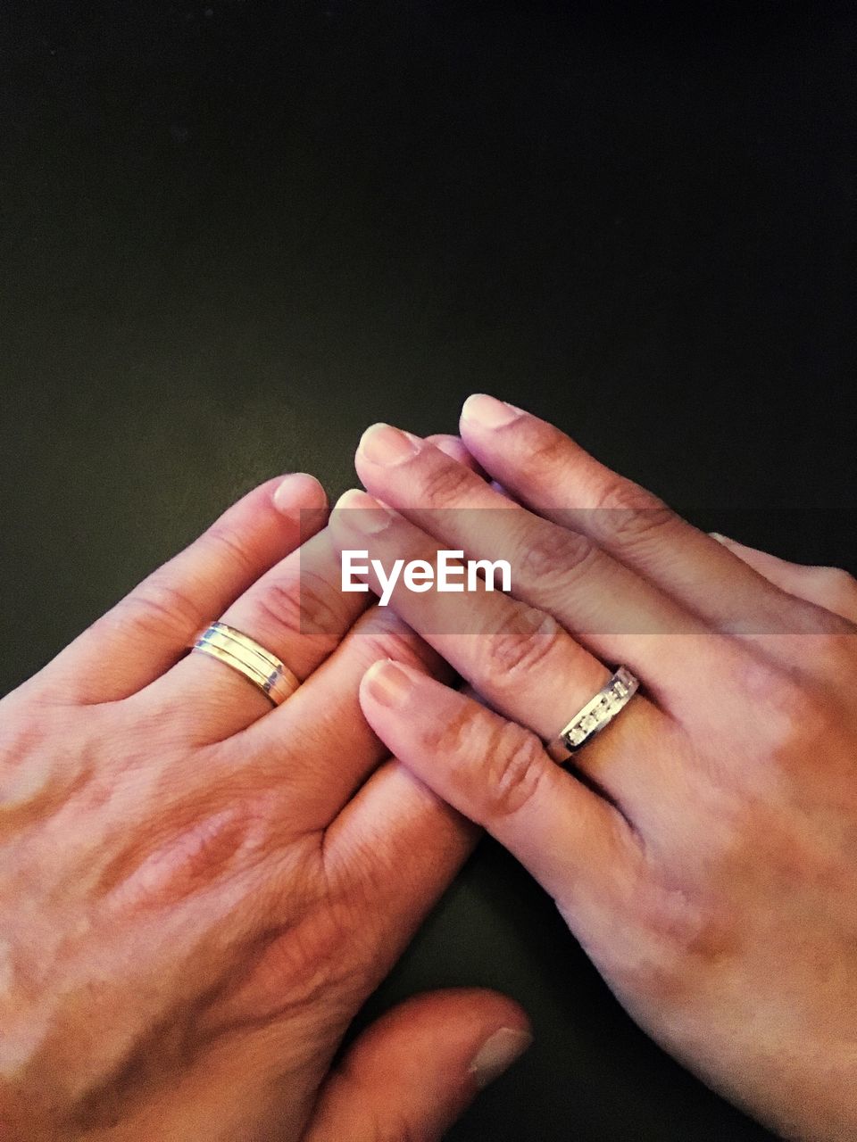 High angle view of couple hands wearing rings