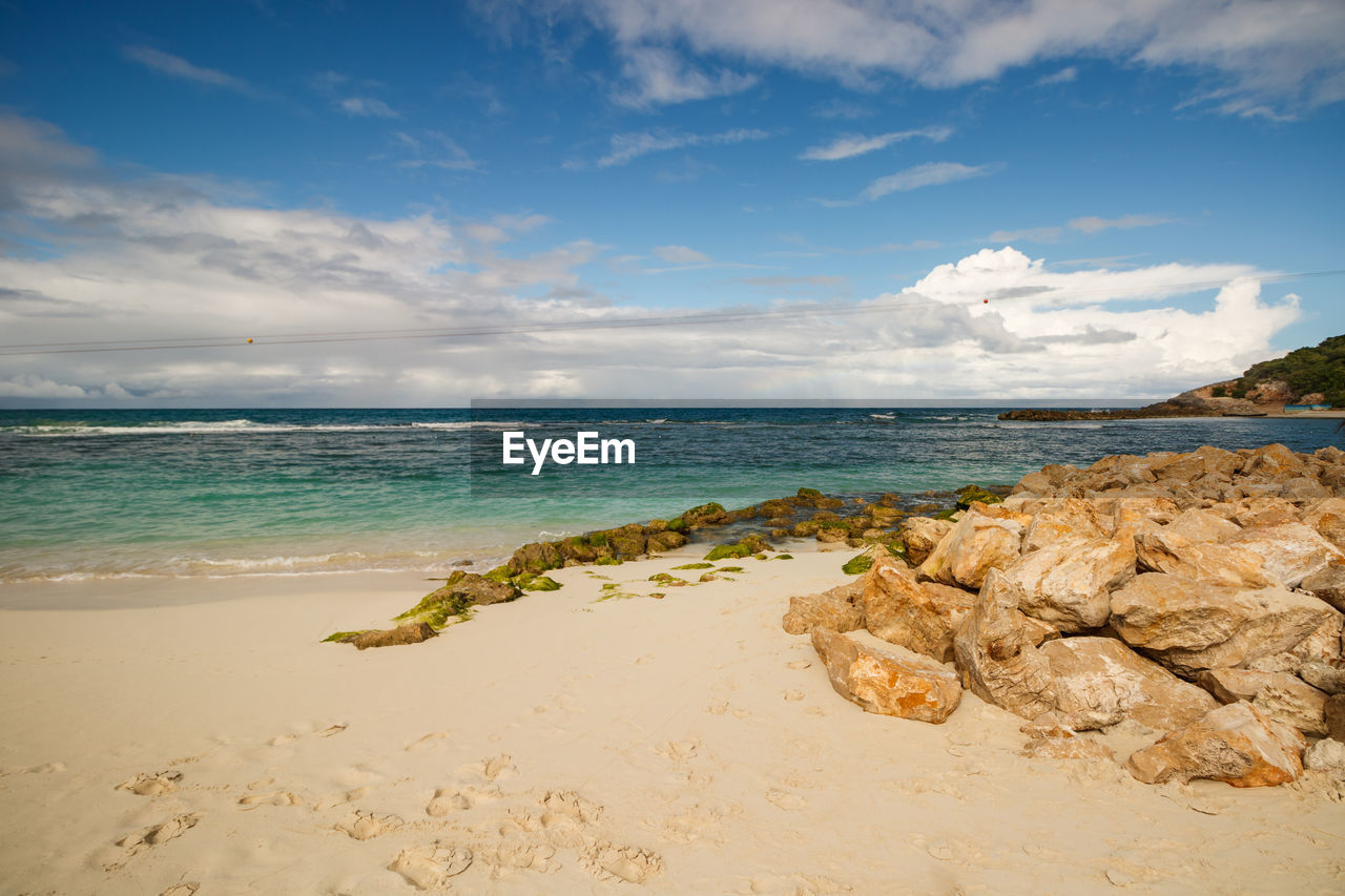 ROCKS ON BEACH AGAINST SKY