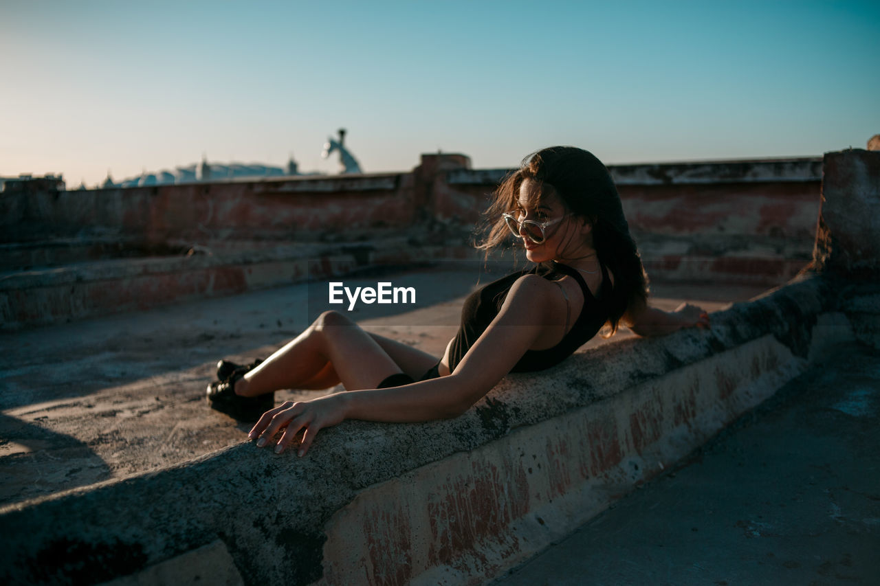 Young woman on terrace against clear sky