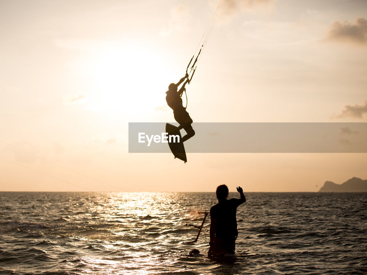 View of silhouette kite surfing in the ocean