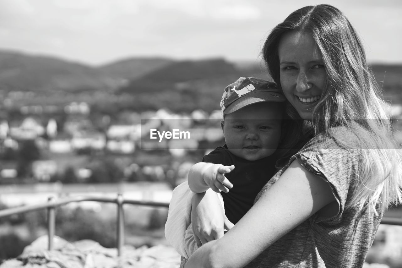 Portrait of mother and son against sky