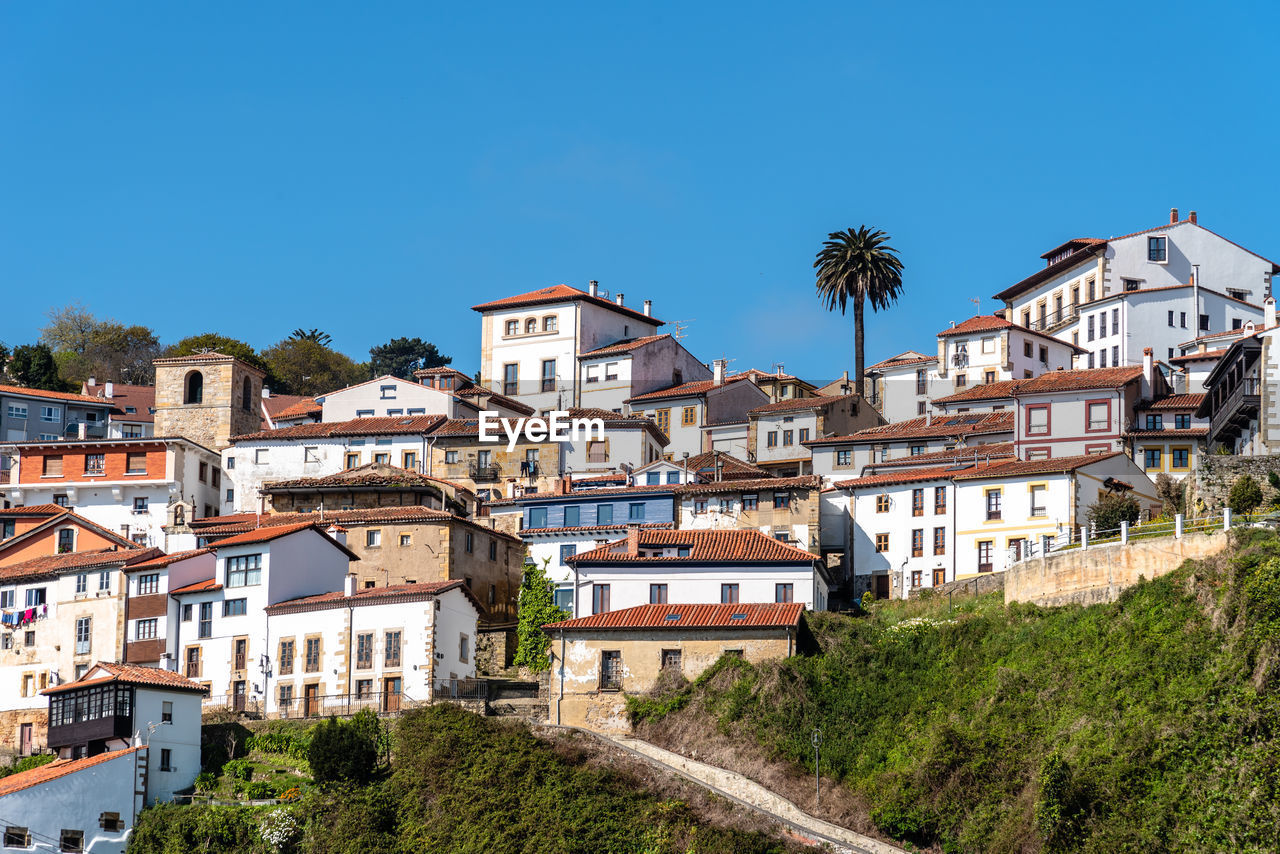 Buildings in town against clear blue sky