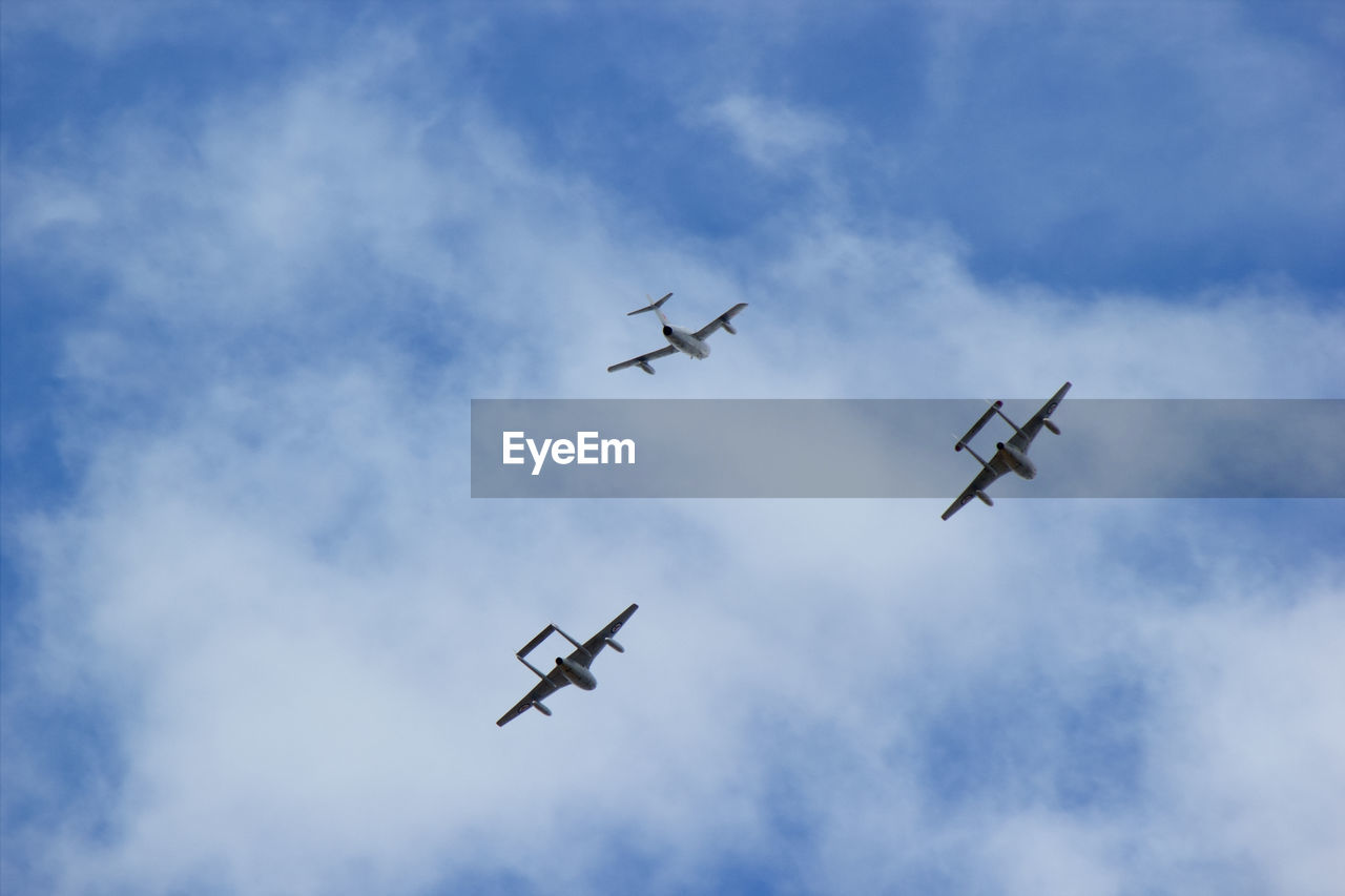 Low angle view of airplanes flying against sky