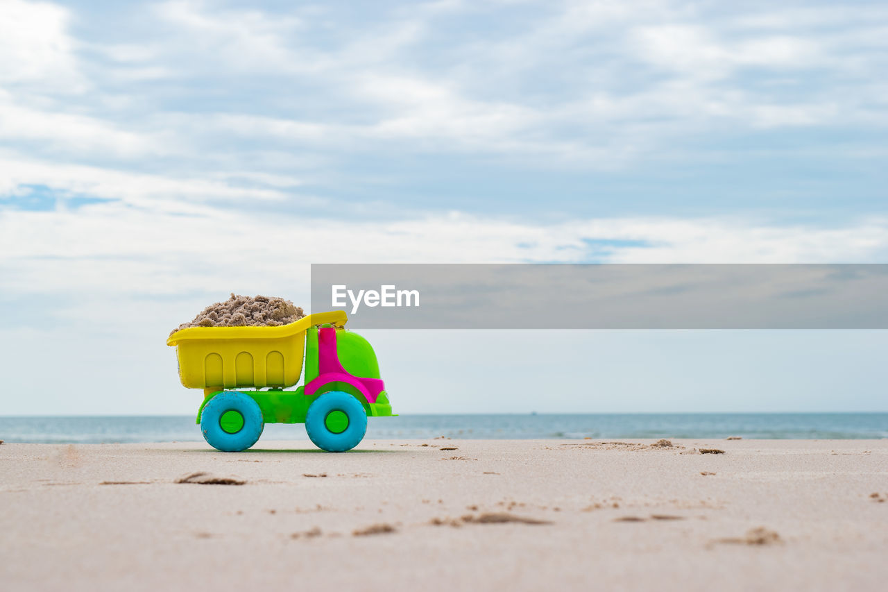 Toy toys on beach against sky