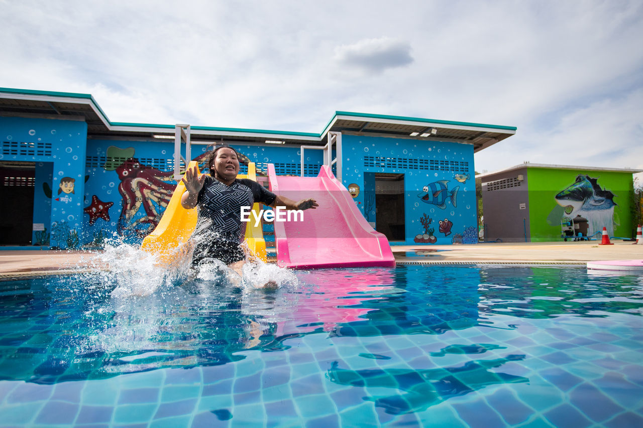 YOUNG WOMAN WITH SWIMMING POOL IN PARK