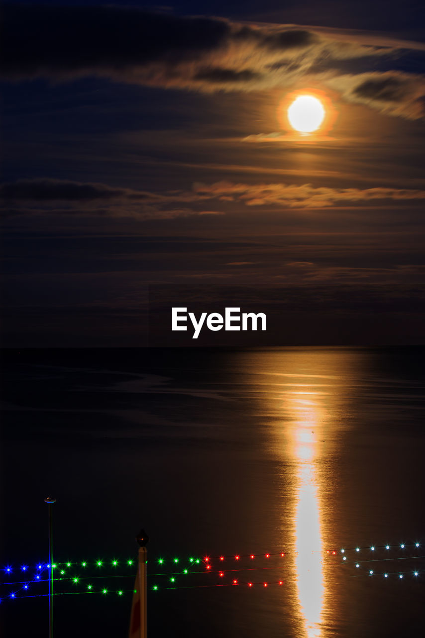 Scenic view of sea against full moon at night