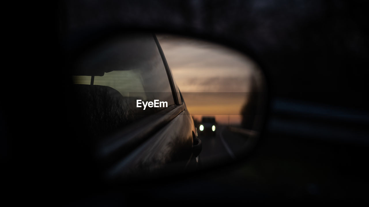 Close-up of side-view mirror with following car