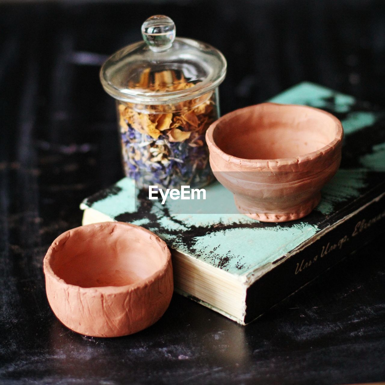 Close-up of ceramic bowls and book on table