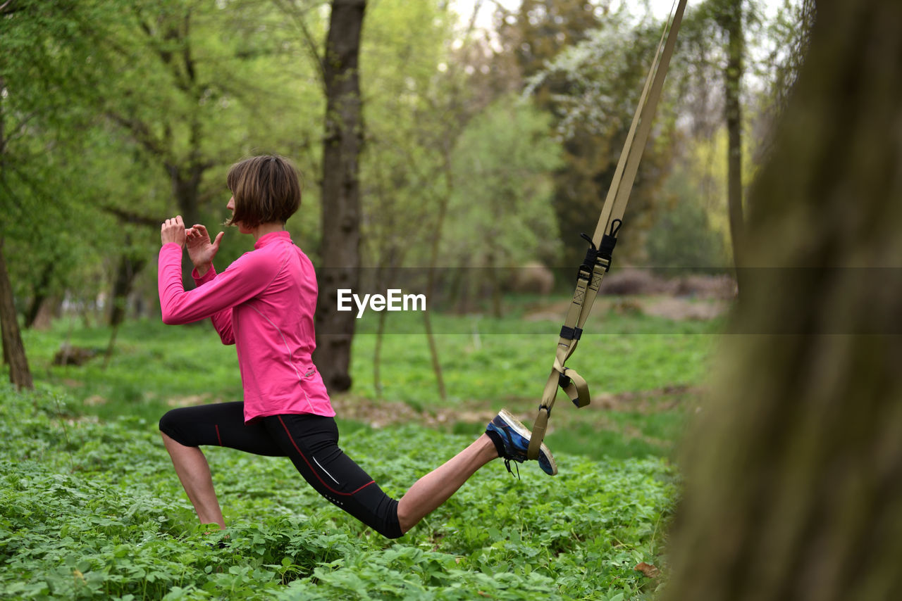 Mid adult woman exercising at public park