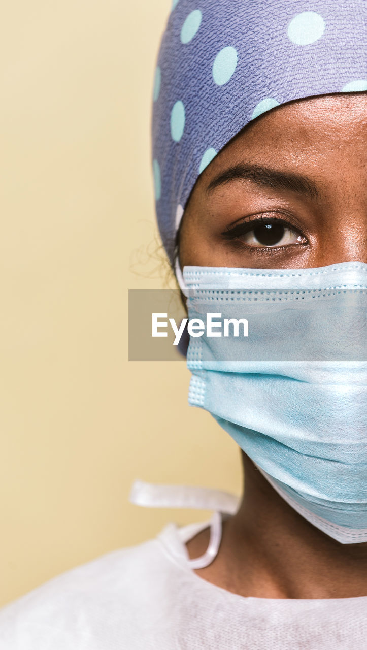 Portrait of doctor wearing mask against blue background