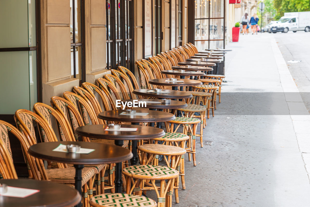 Empty chairs and tables in cafe outdoors