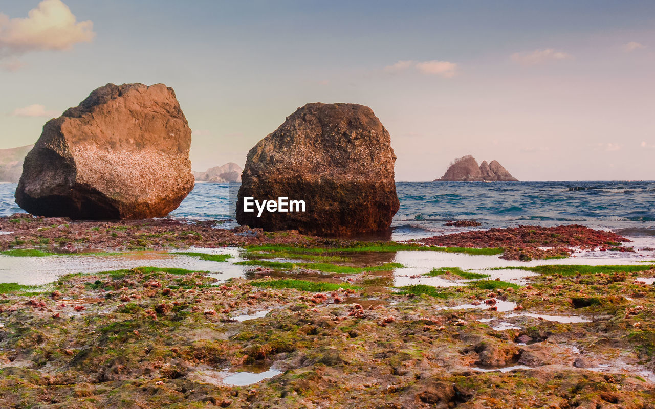 ROCKS IN SEA AGAINST SKY