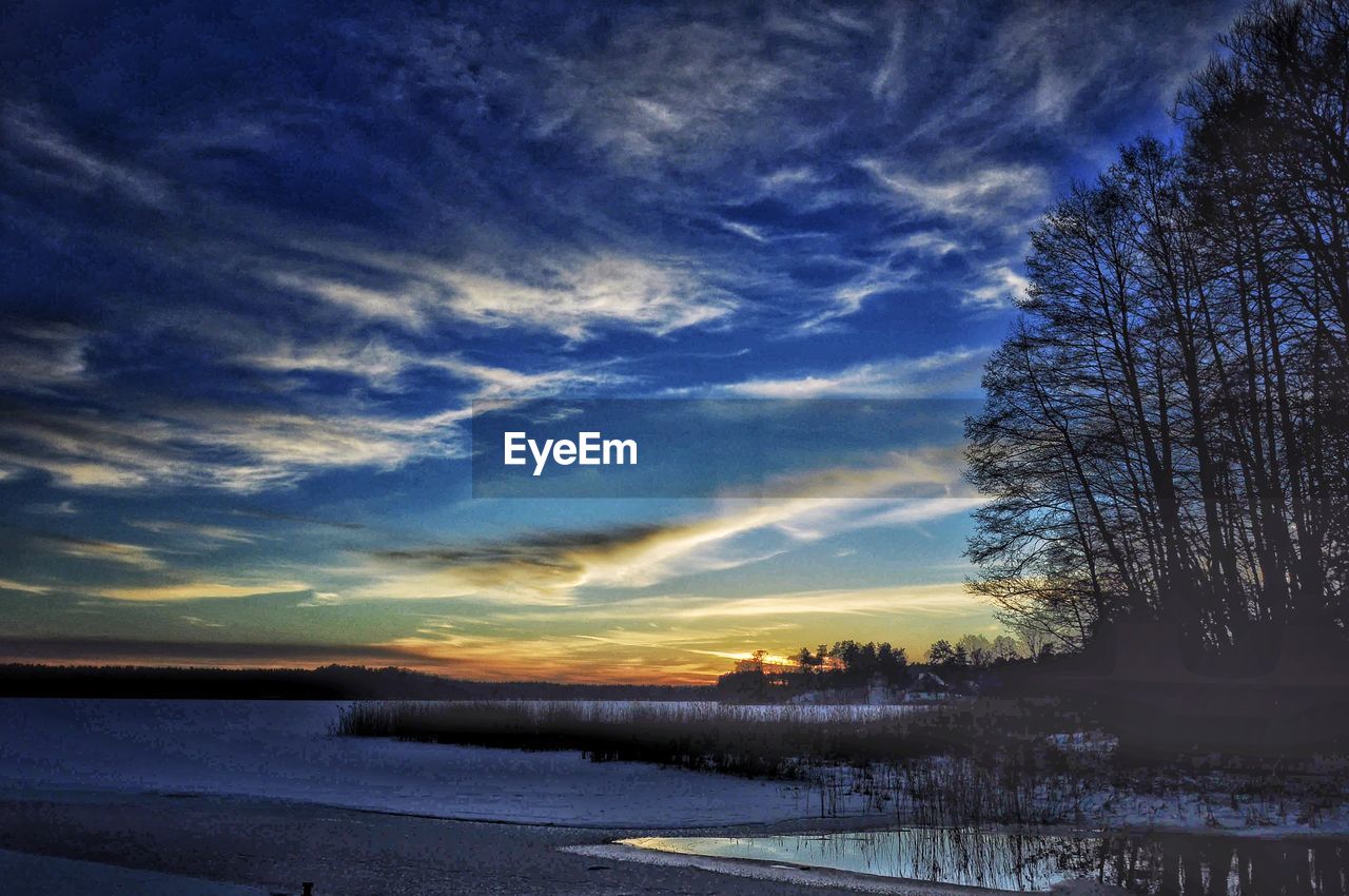 SCENIC VIEW OF LAKE DURING WINTER AGAINST SKY