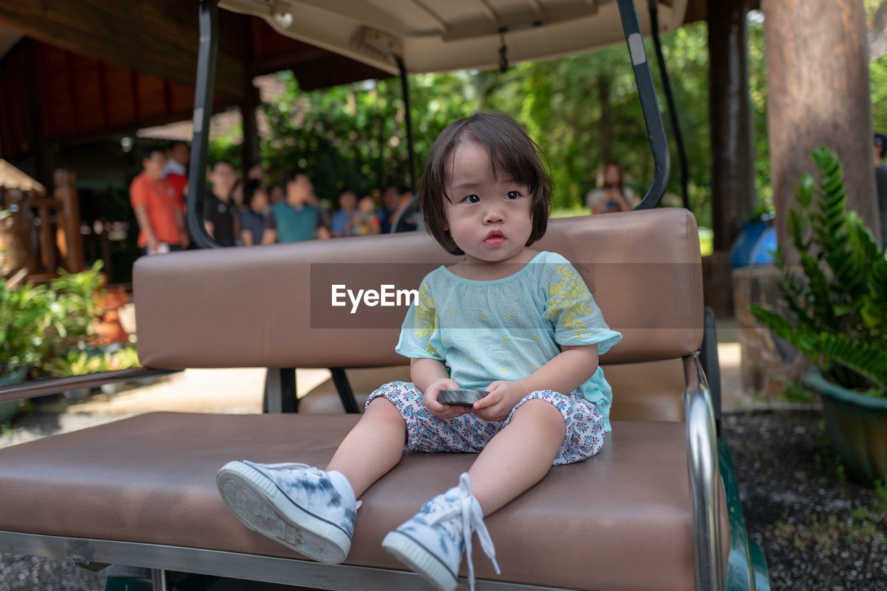 Cute girl sitting on golf cart