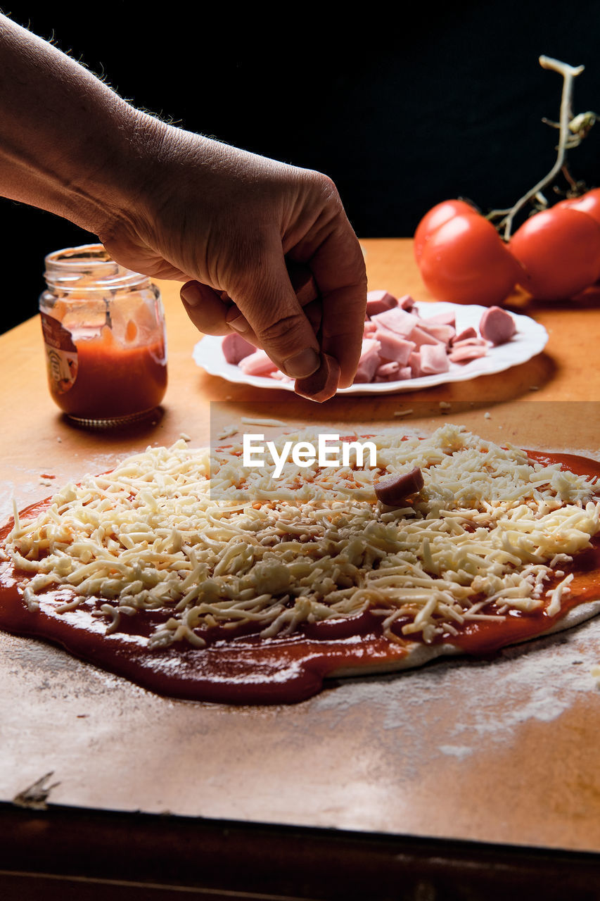 Preparing pizza base at home, we put tomato, cheese,...