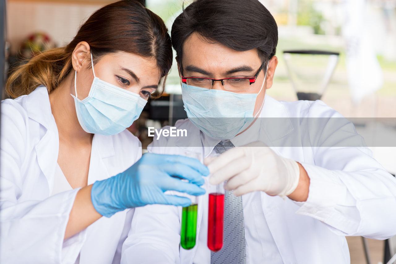 Man and woman examining test tubes in laboratory