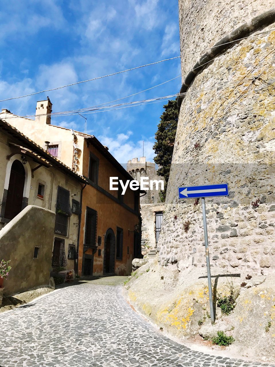 ROAD SIGN BY BUILT STRUCTURE AGAINST SKY