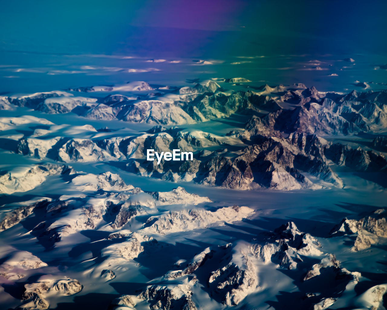 Aerial view of snowcapped mountains against sky