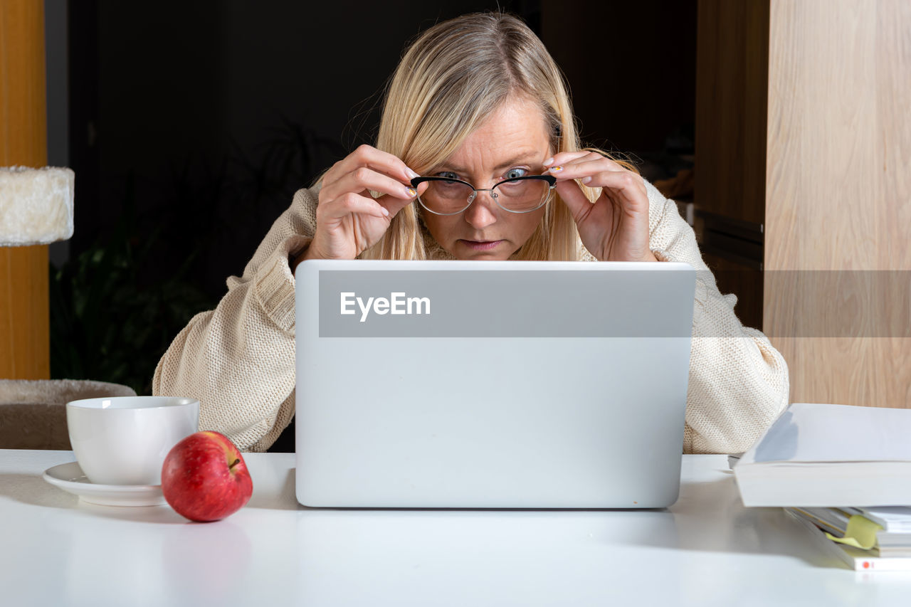 Portrait of woman using laptop on table