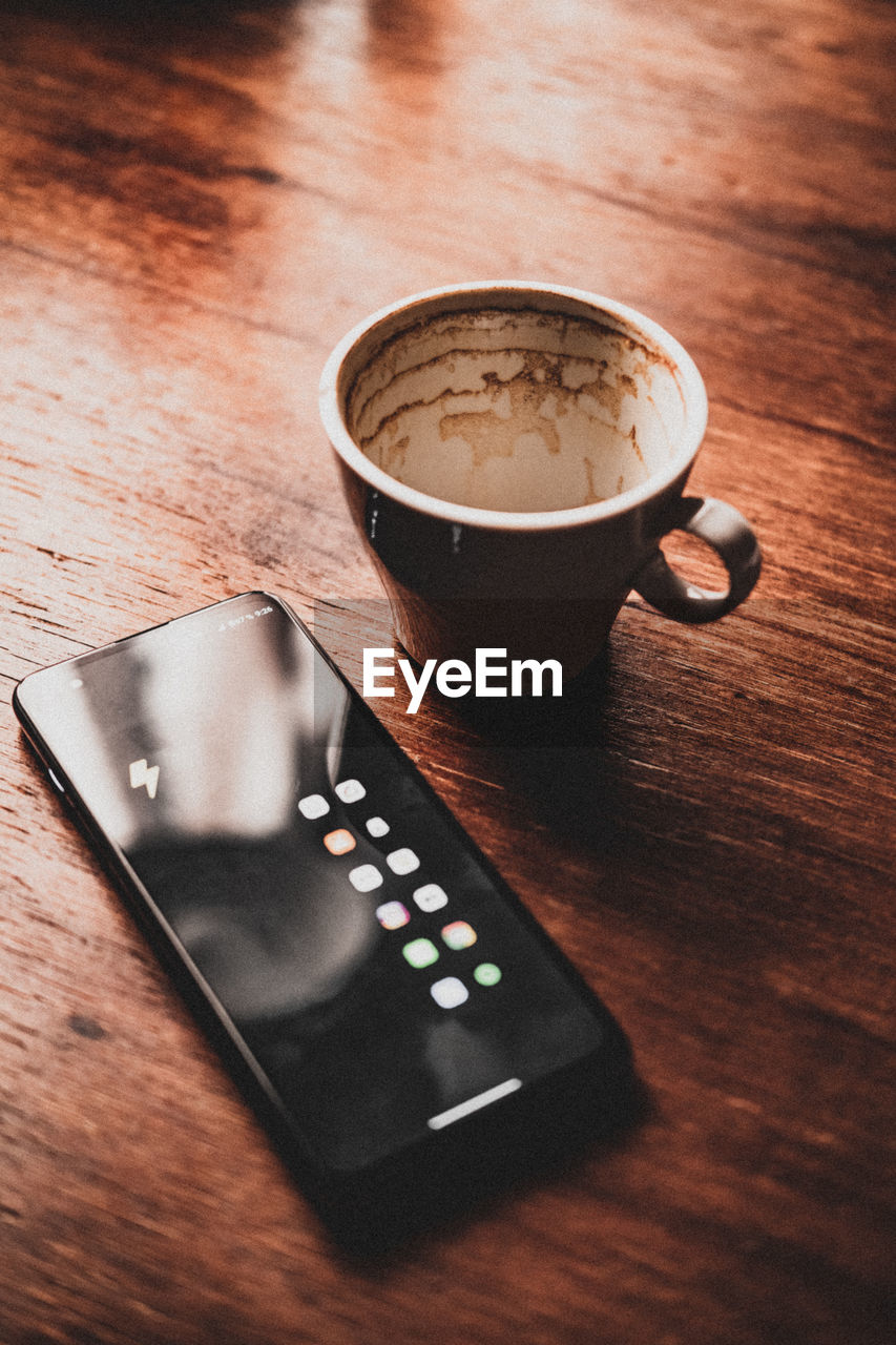 Close-up of coffee  and a cellphone on table