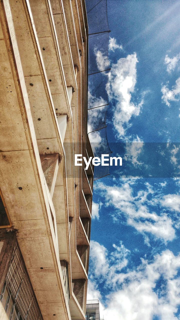 LOW ANGLE VIEW OF BUILDING AGAINST CLOUDY SKY