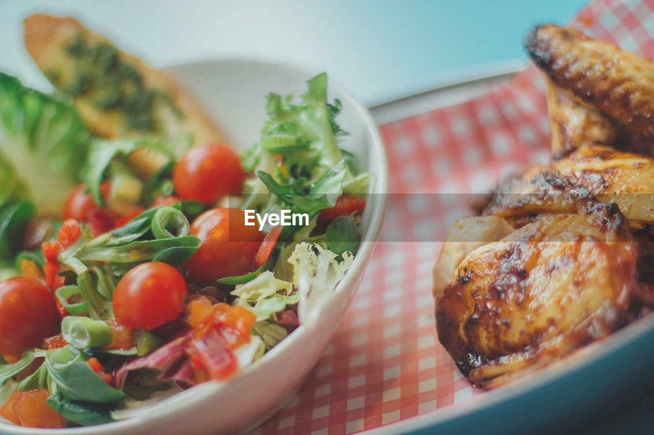 Close-up of roasted chicken and salad served in plate