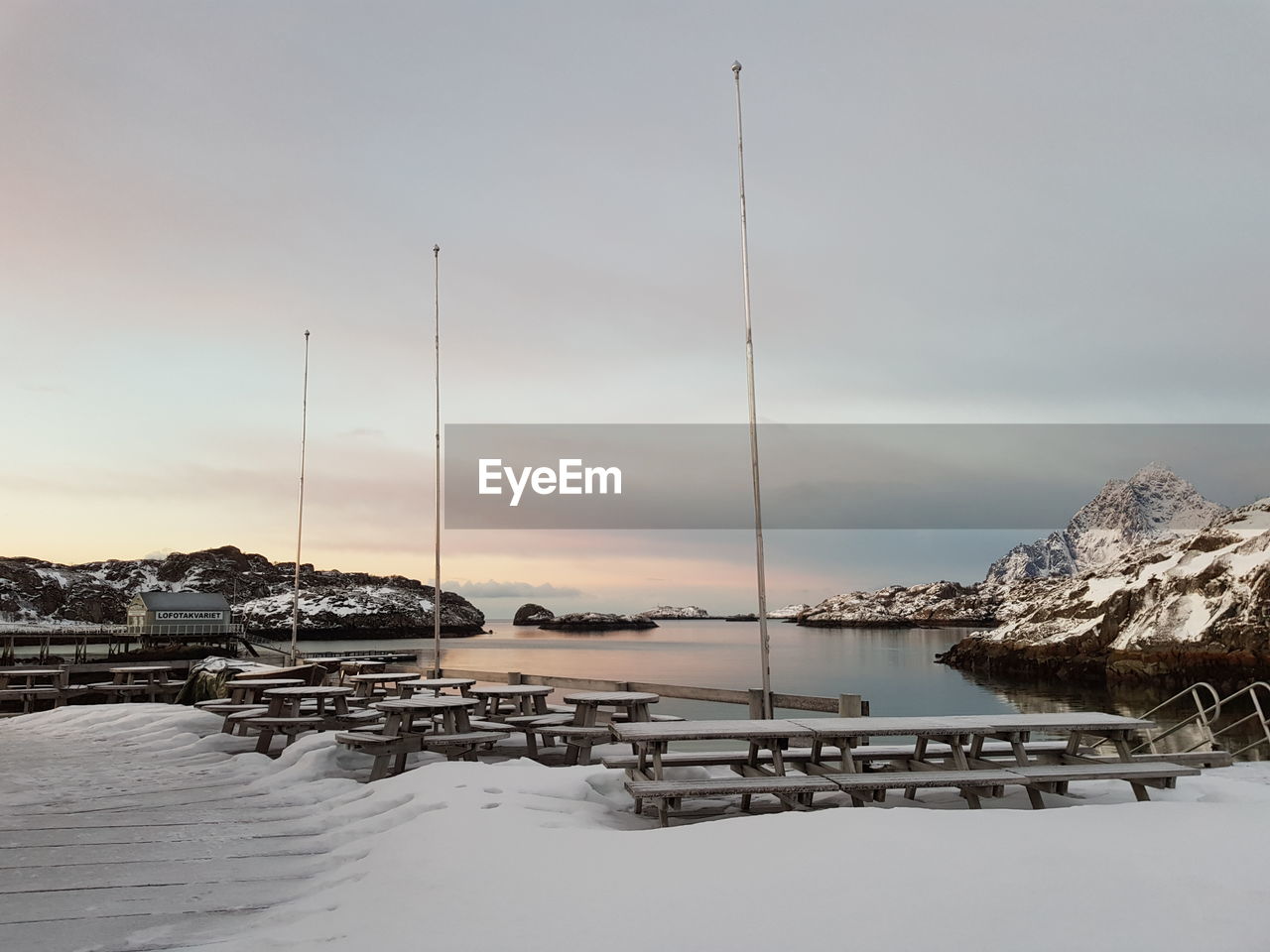 Scenic view of sea and snowcapped mountains against sky