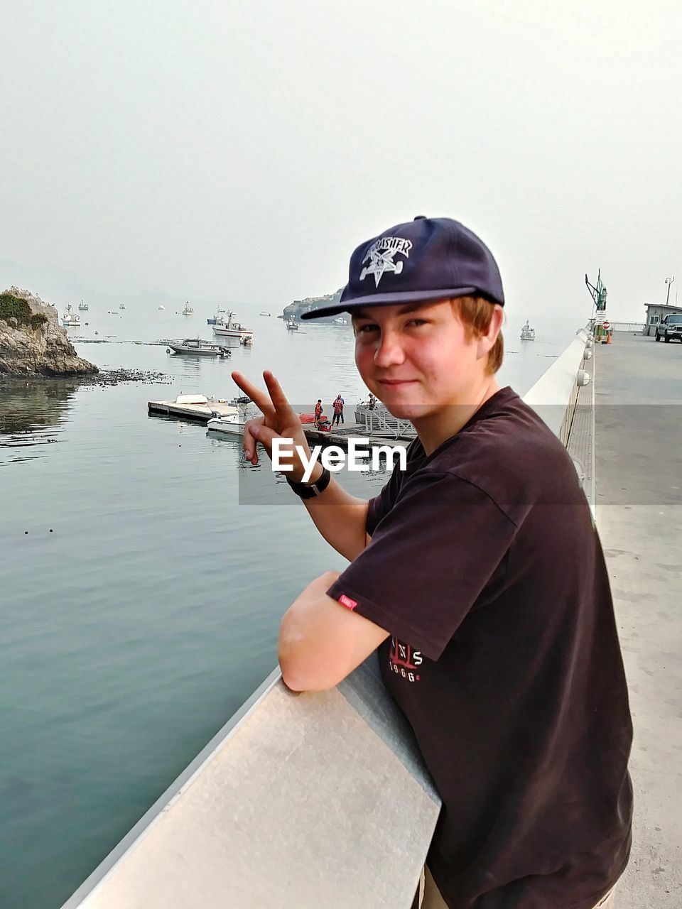 PORTRAIT OF BOY STANDING BY RIVER AGAINST SKY