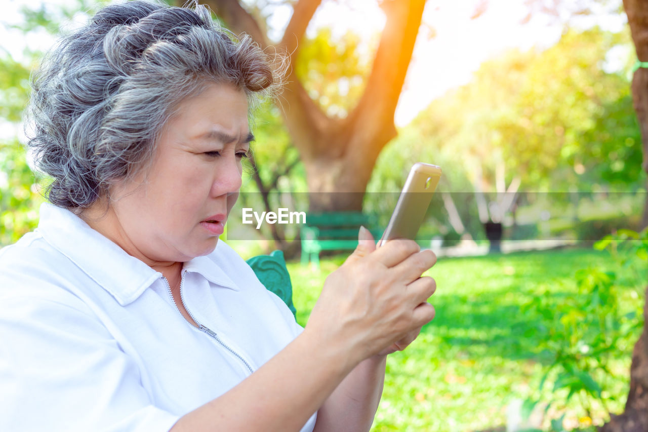 Senior woman using smart phone at park