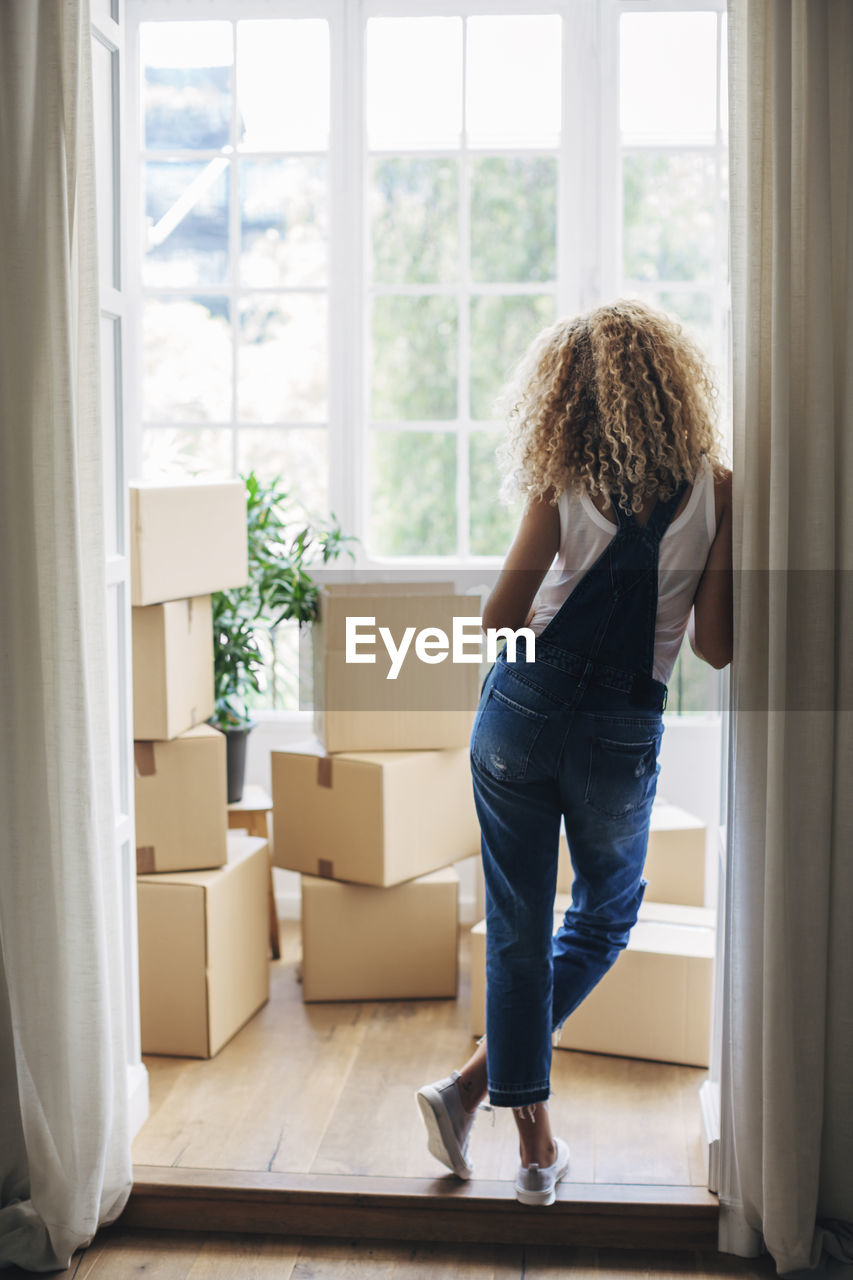 Rear view of woman standing at doorway in new house