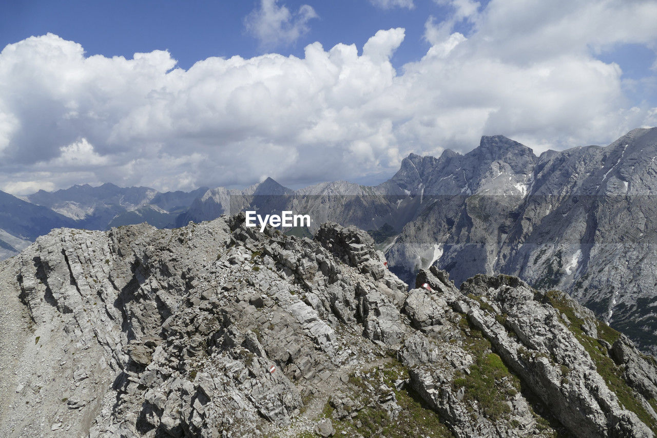 mountain, sky, cloud, scenics - nature, environment, mountain range, landscape, adventure, beauty in nature, ridge, nature, wilderness, mountain pass, walking, rock, travel destinations, travel, land, no people, backpacking, summit, outdoors, mountain peak, day, activity, snow, tranquility, leisure activity, tourism, plateau, tranquil scene, non-urban scene, cold temperature, valley, cirque, extreme terrain, panoramic, blue, winter, high up, pinaceae, mountaineering