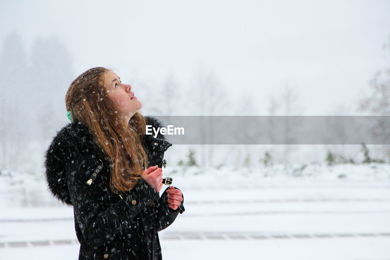 Young woman standing on snow covered landscape