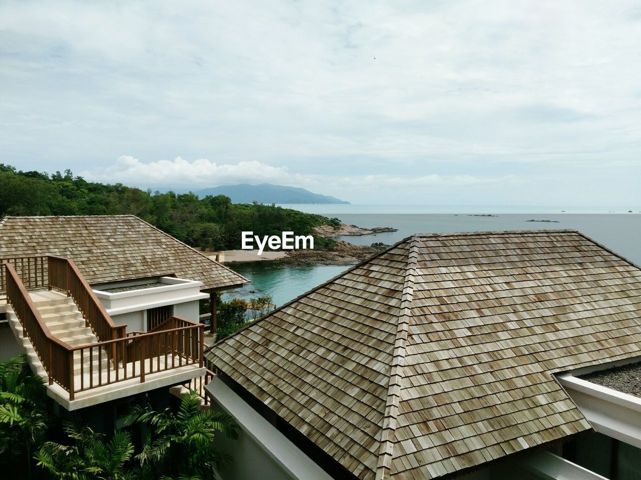 HIGH ANGLE VIEW OF BUILDINGS BY SWIMMING POOL AGAINST SKY