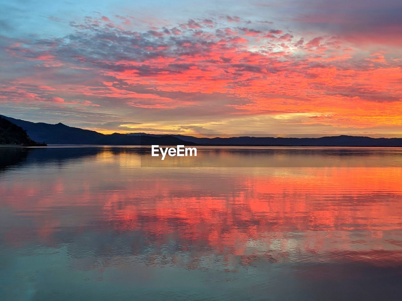 SCENIC VIEW OF LAKE AGAINST SKY DURING SUNSET