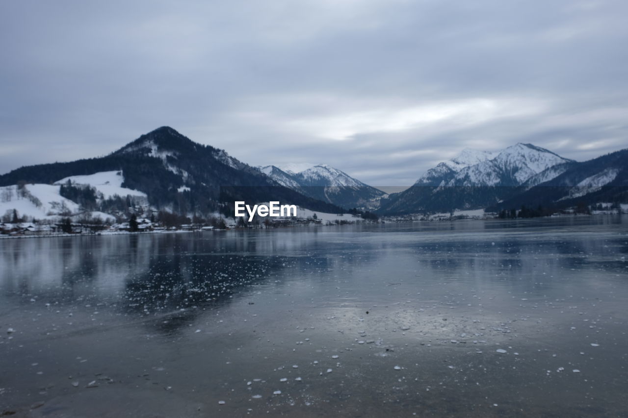 Scenic view of lake and snowcapped mountains against sky