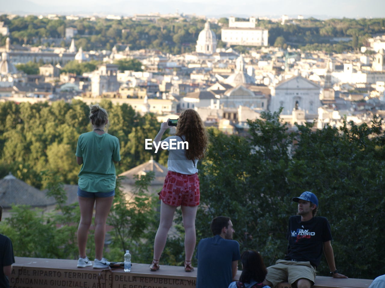 REAR VIEW OF PEOPLE STANDING ON CITY