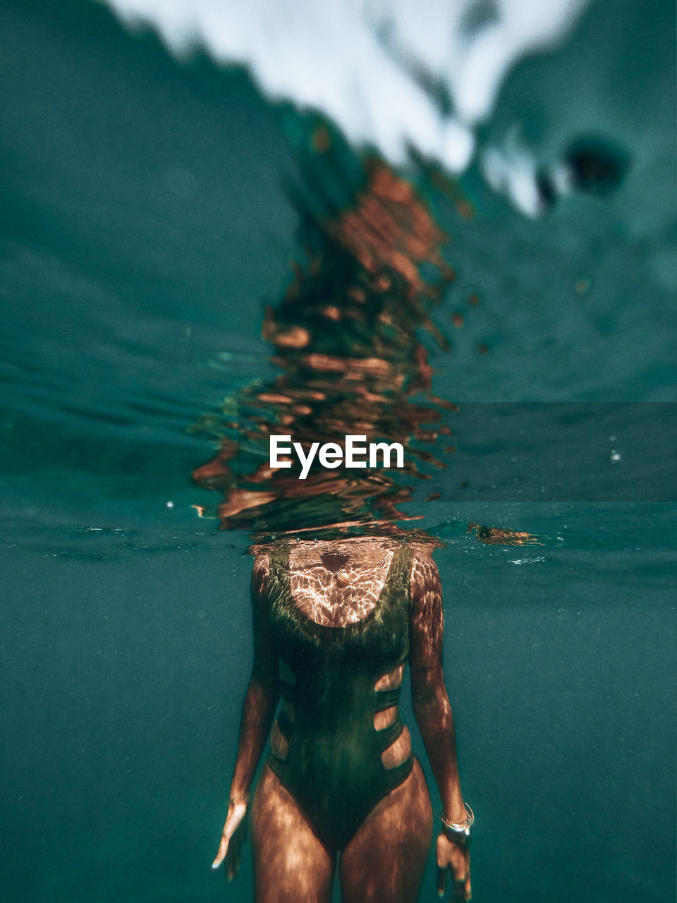 Midsection of woman swimming in sea