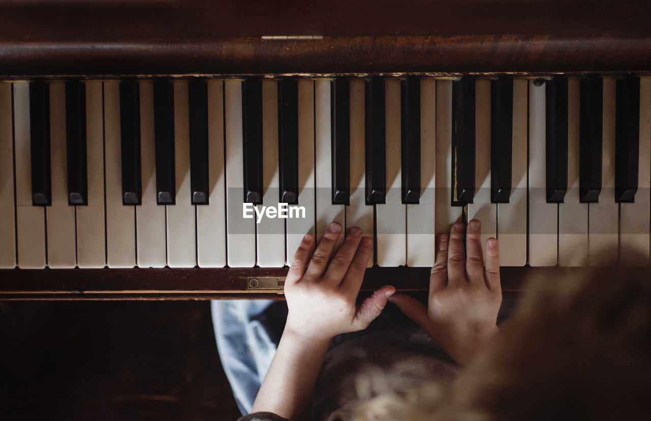 High angle view of girl playing piano at home