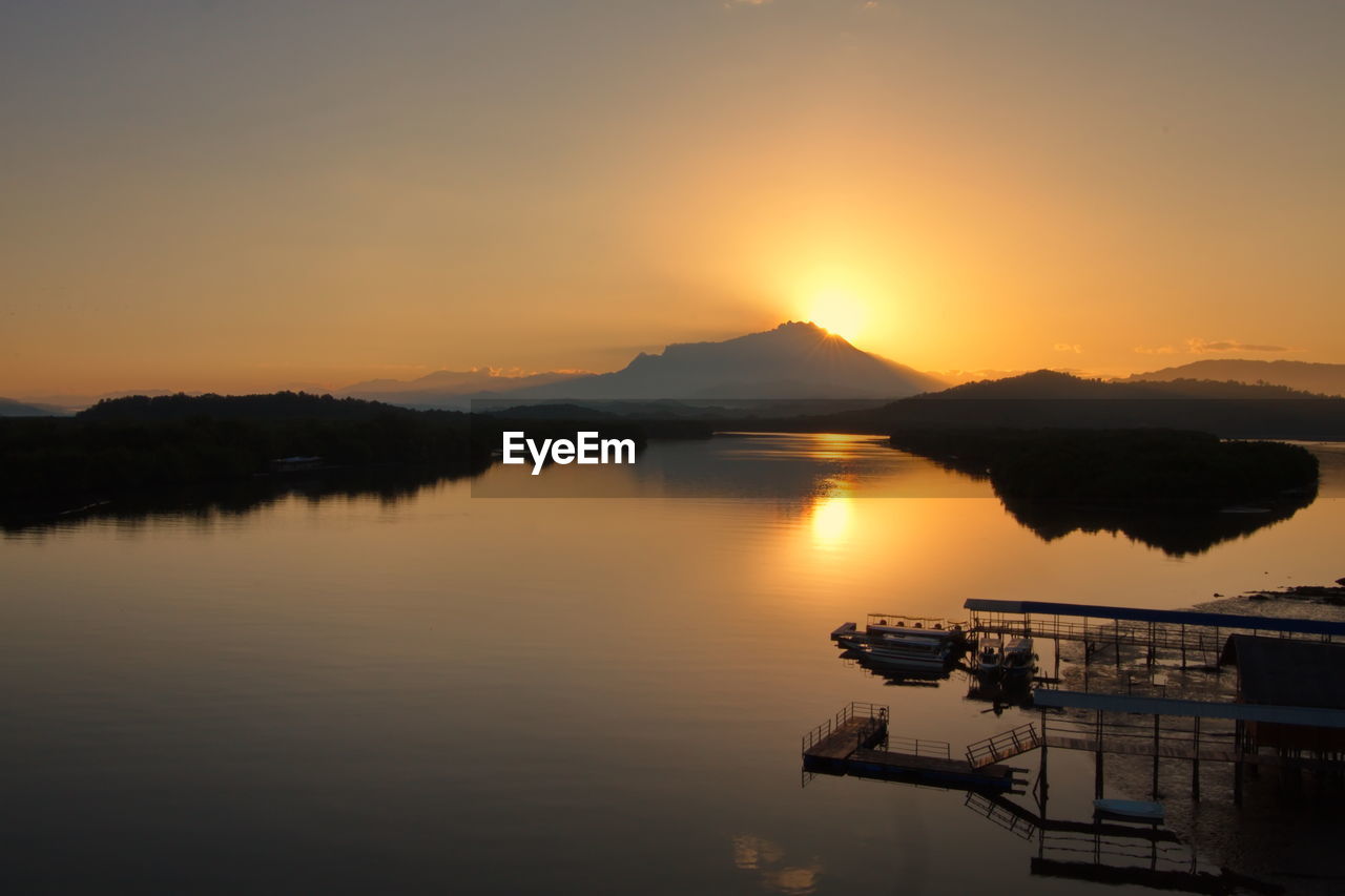 SCENIC VIEW OF LAKE AGAINST SKY AT SUNSET