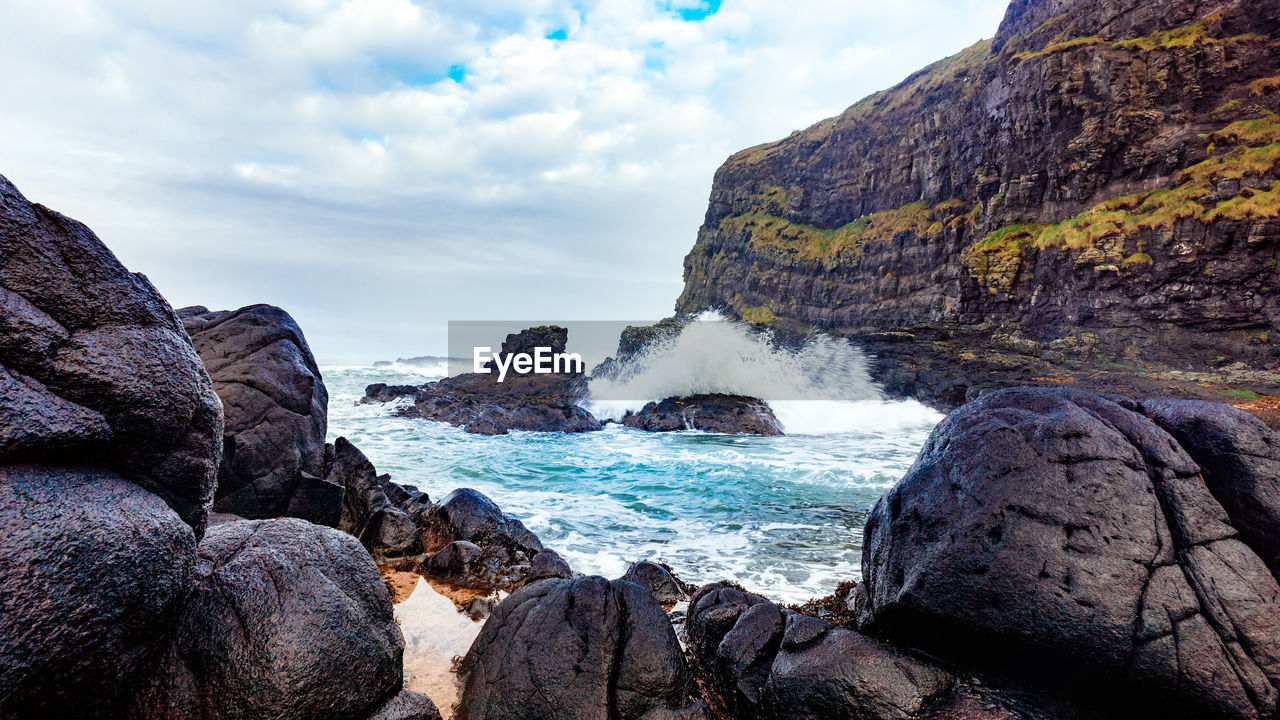 Scenic view of waves crashing at rocky beach