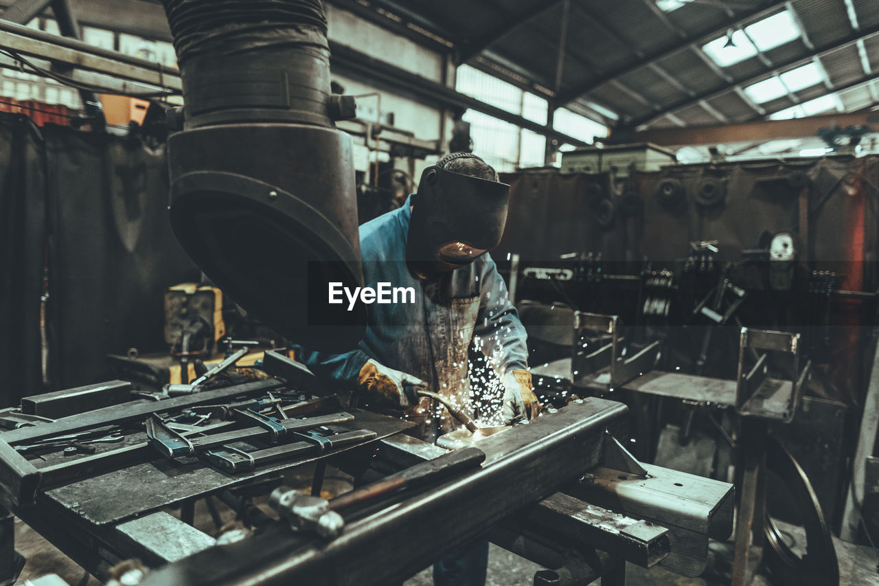 Welder welding metal in a factory