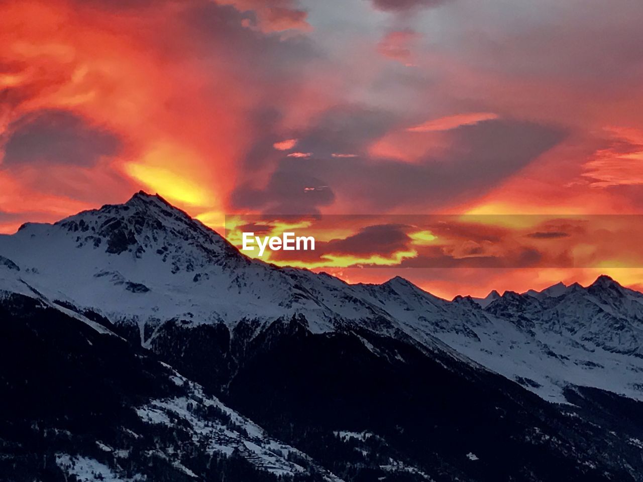 SNOWCAPPED MOUNTAINS AGAINST SKY DURING SUNSET