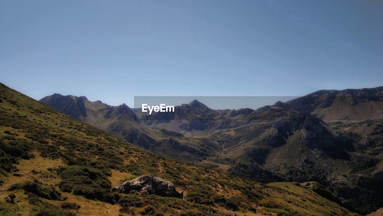 Scenic view of mountains against clear blue sky