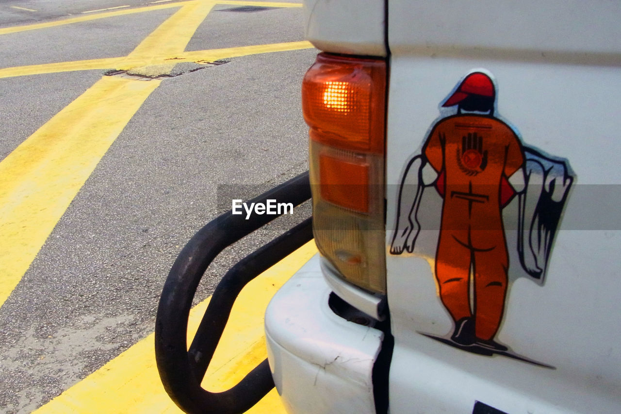 CLOSE-UP OF YELLOW CAR ON STREET