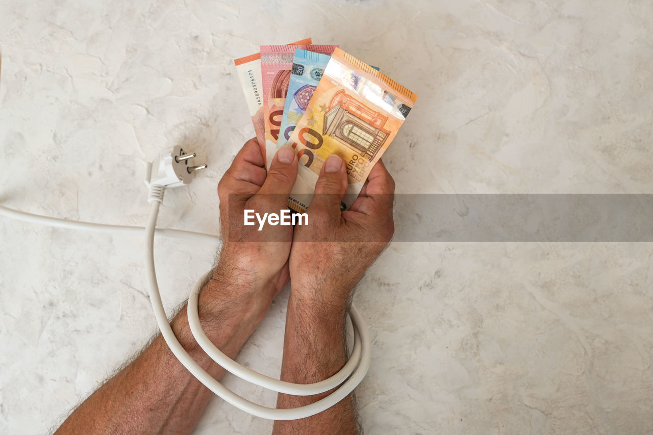 finance, paper currency, currency, hand, one person, business, holding, wealth, adult, indoors, high angle view, savings, finance and economy