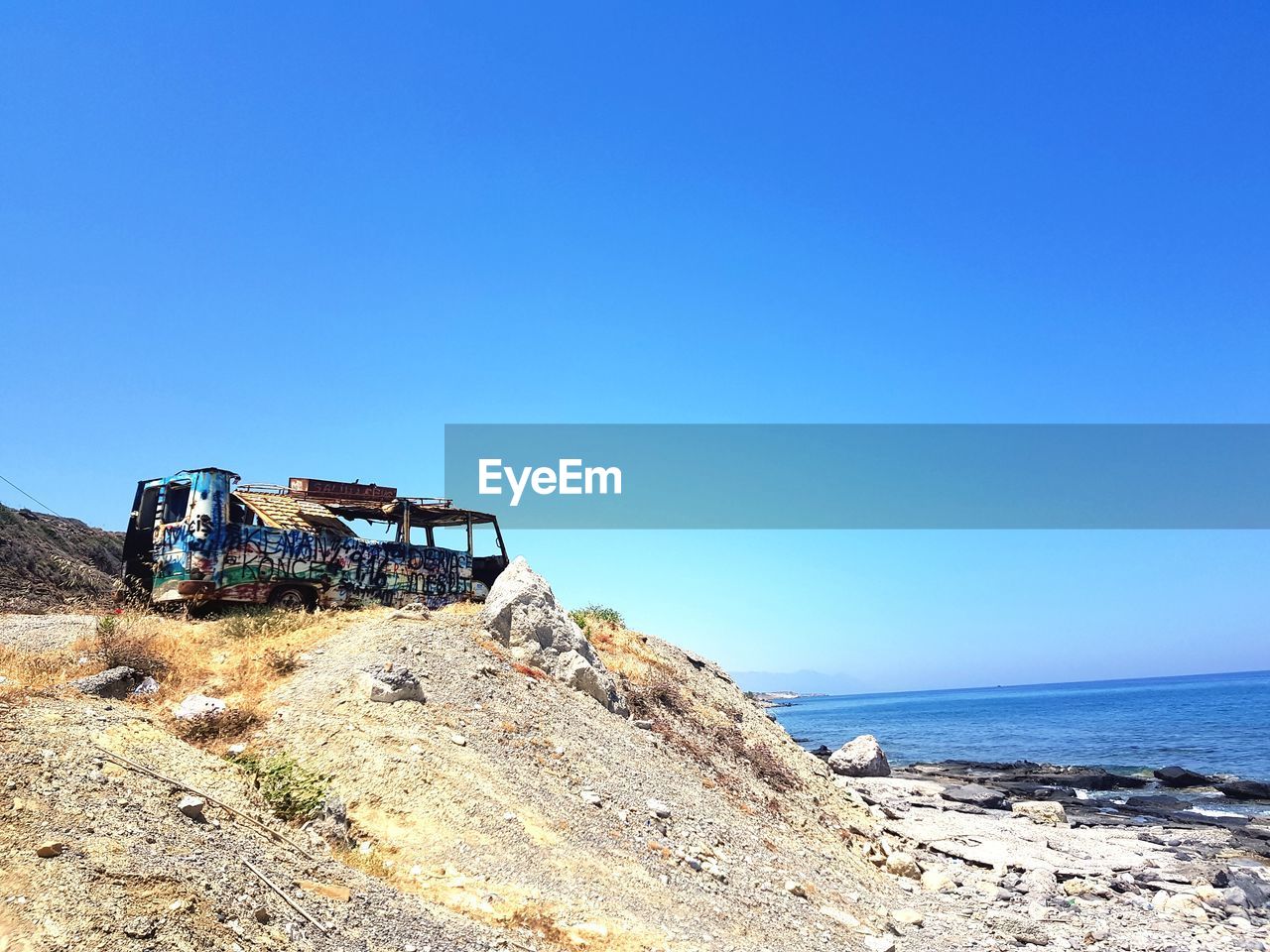 Abandoned vehicle against clear blue sky