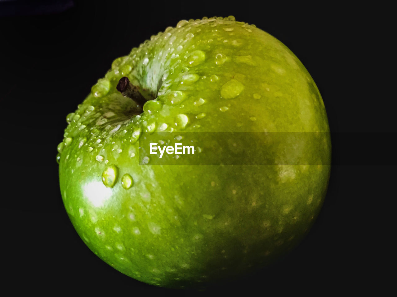 Close-up of green apple against black background