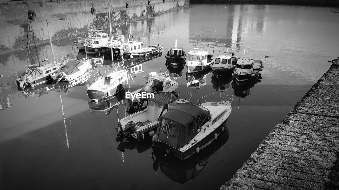 HIGH ANGLE VIEW OF MOORED BOATS IN WATER