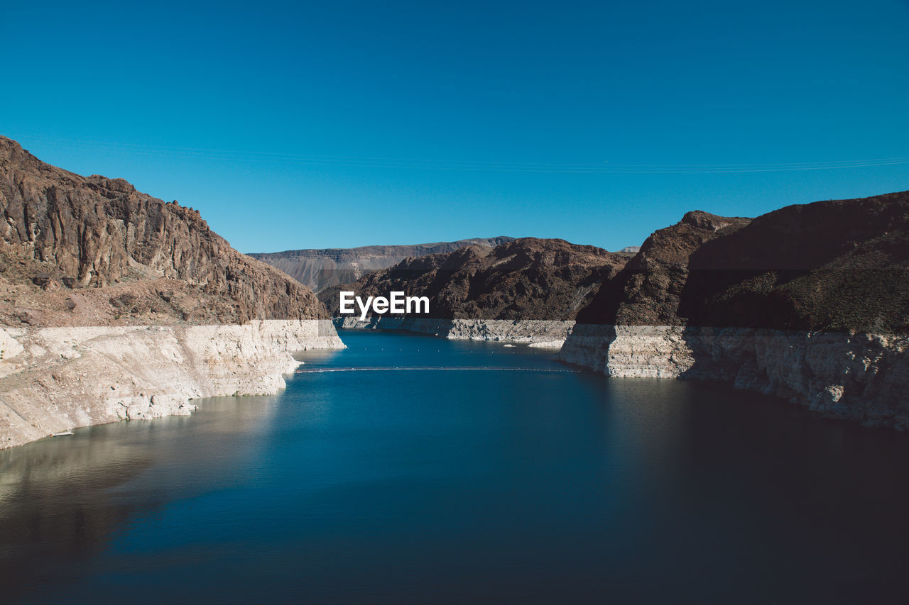 Colorado river amidst mountains against blue sky