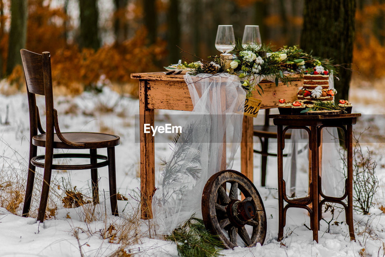 EMPTY CHAIRS AND TABLE ON SNOW FIELD